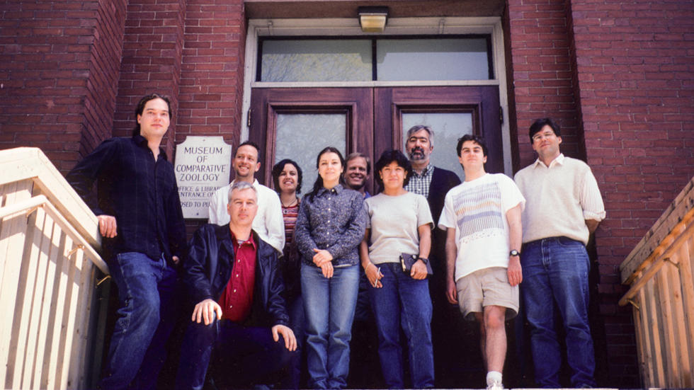 10 Farrell Lab members standing at the top of the steps to the Harvard MCZ
