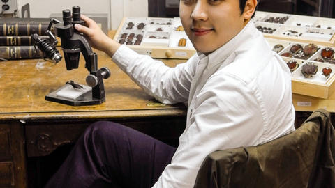 Sang Il Kim at desk with microscope