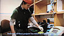 Screenshot of video, showing Whit Farnum in lab, conducting research