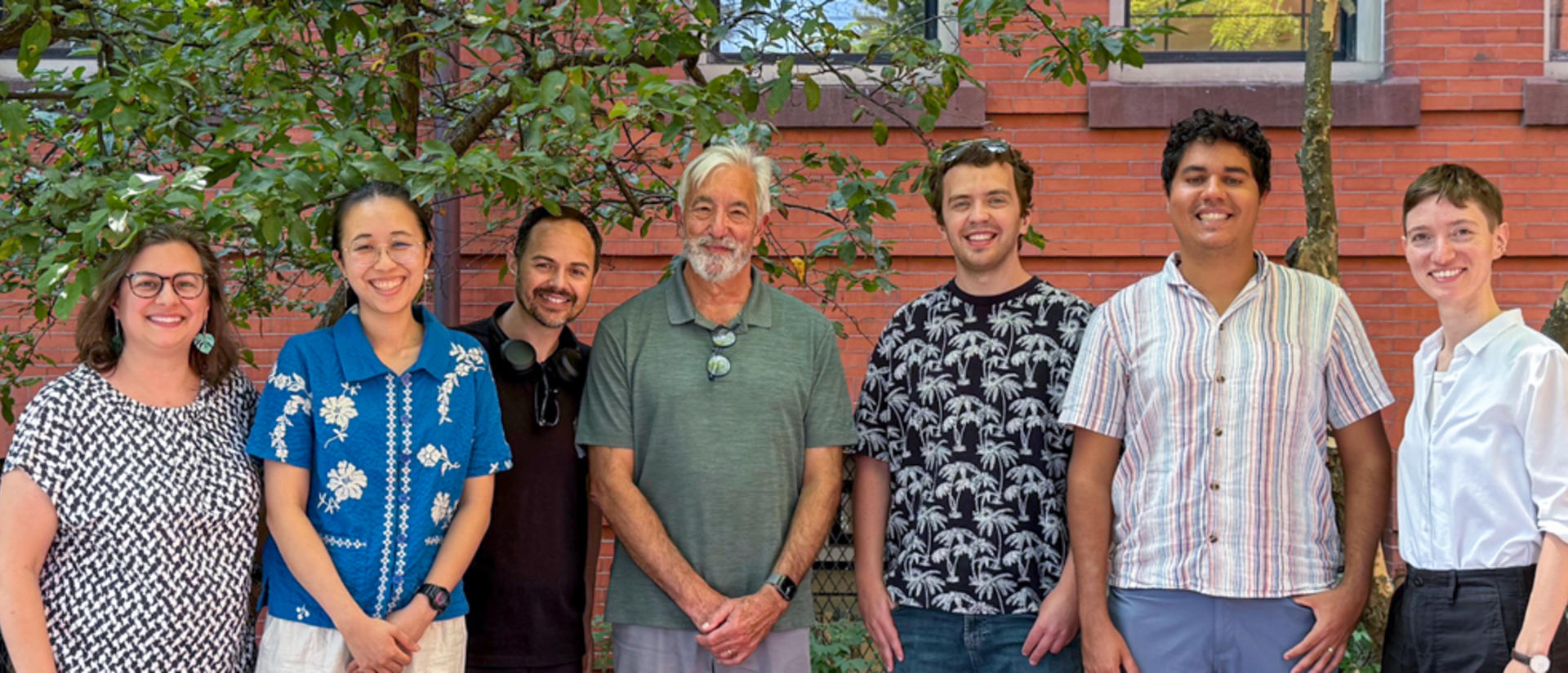 Farrell Lab members side by side, in front of brick and leaves