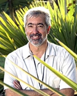 Brian Farrell smiling, with plants in background and foreground
