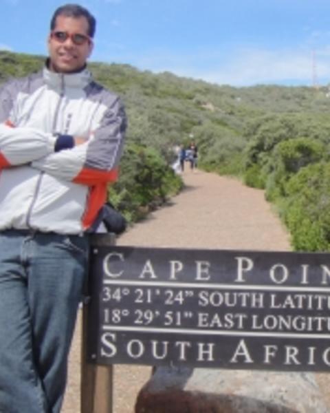 Fabio Laurindo da Silva outdoors, leaning against sign for Cape Point, South Africa