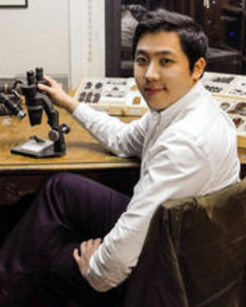 Sang Il Kim at desk with microscope